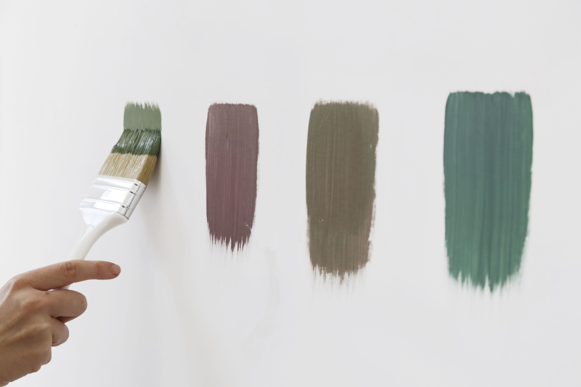 A different color swatches on the white wall. Process of choosing the right color for the wall, DIY home improvement concept.